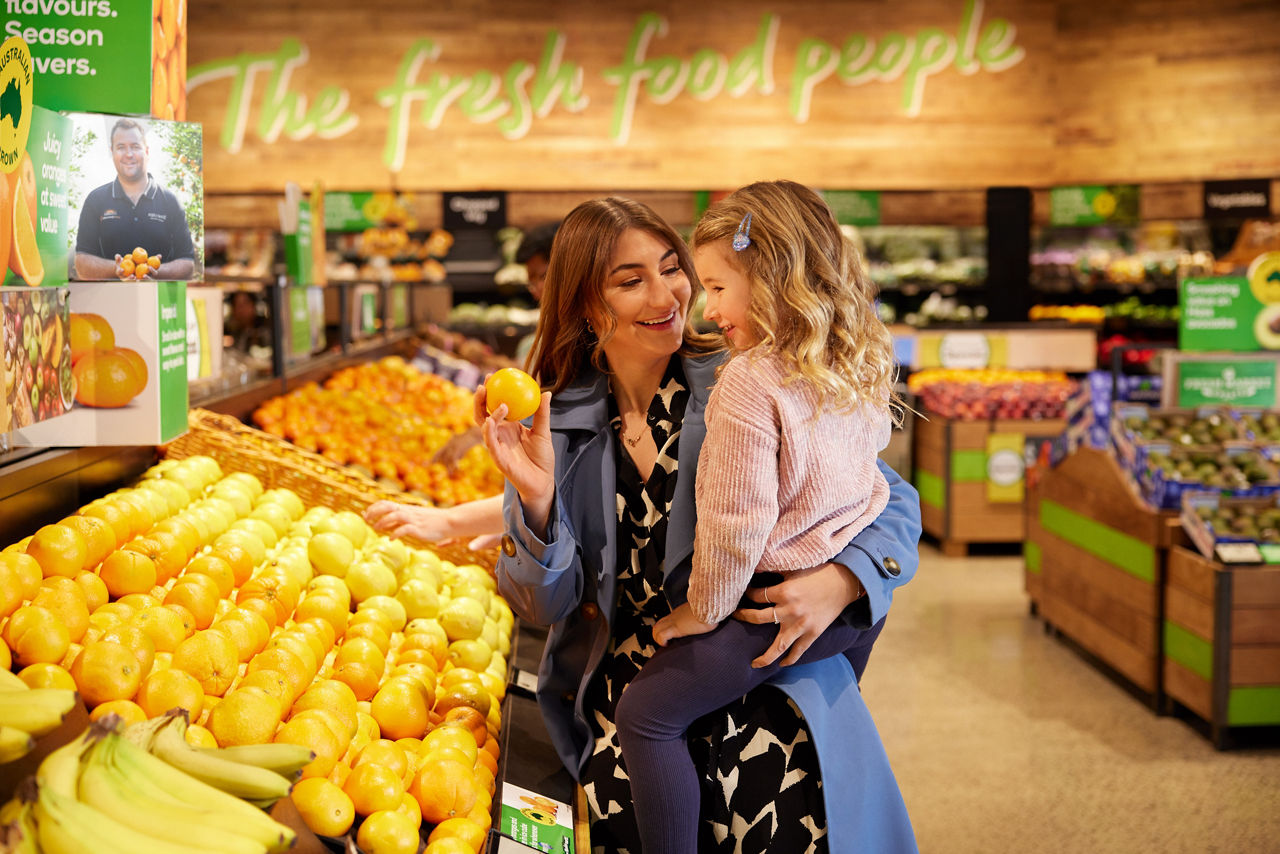 A group of employees from Woolworths Group smiling and standing together