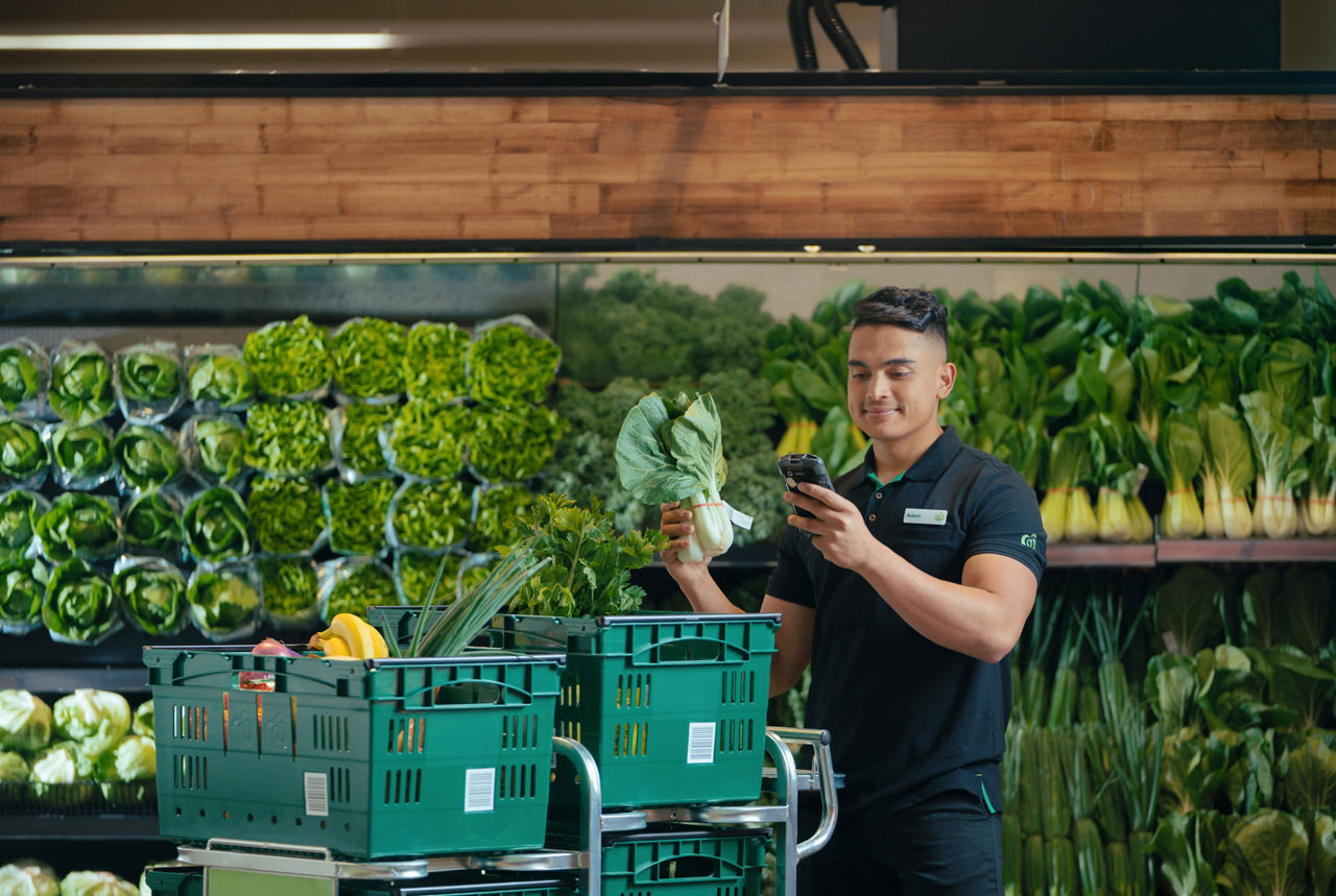 A man scanning and packing an order at the supermarket