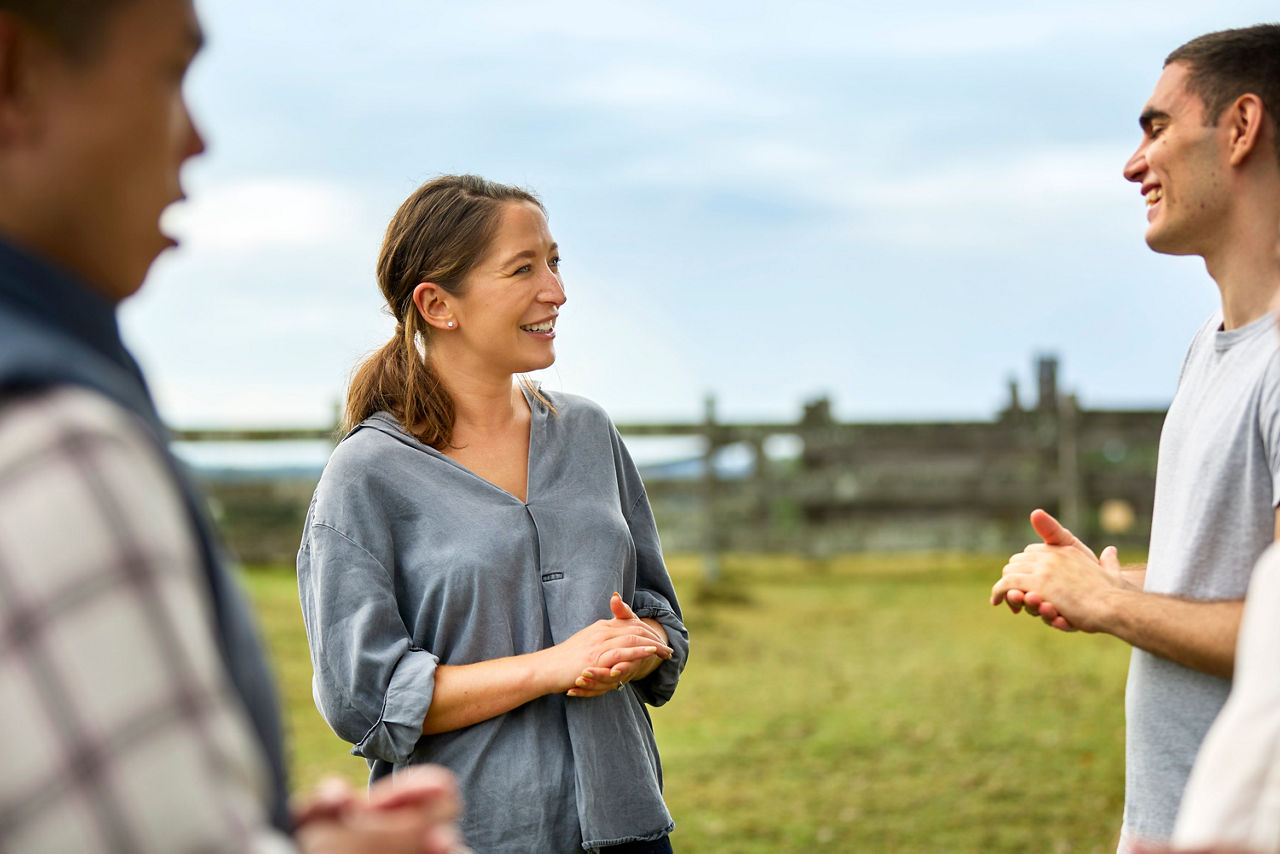 A group of young men and women talking at a farm