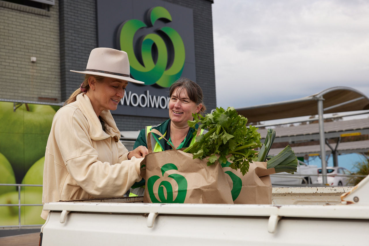 Woolworths customer being passed groceries by a team member at a regional stores