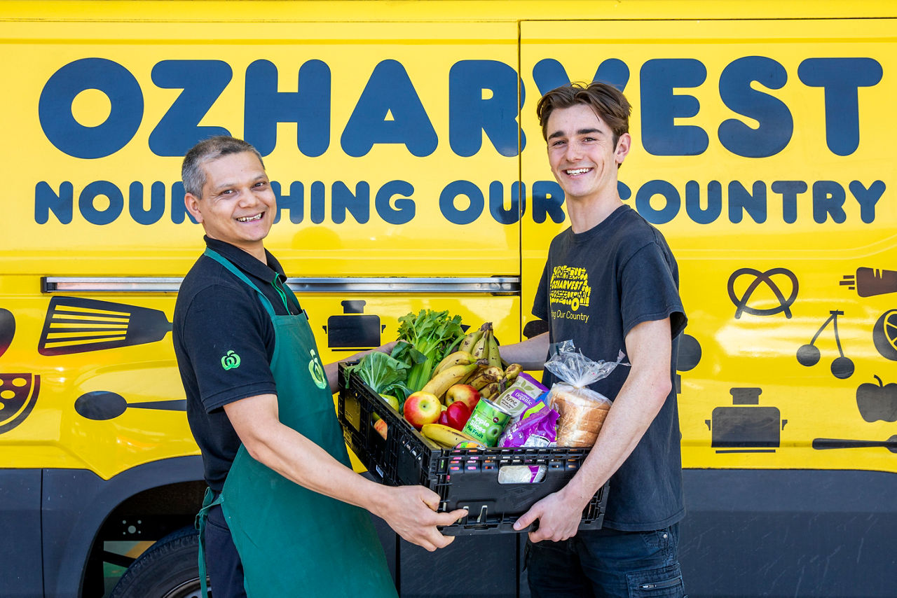 Two people holding groceries in a crate