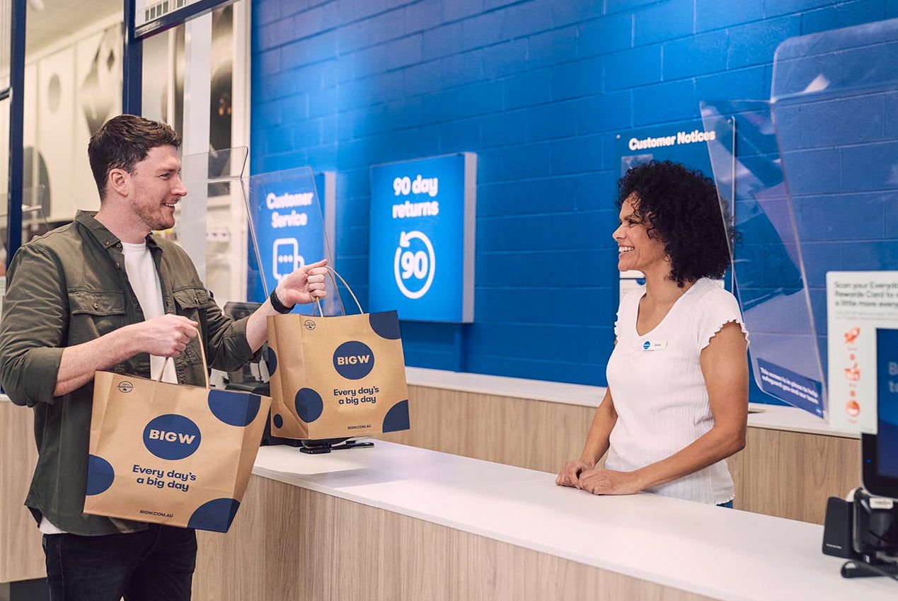 A man collecting his shopping from the register